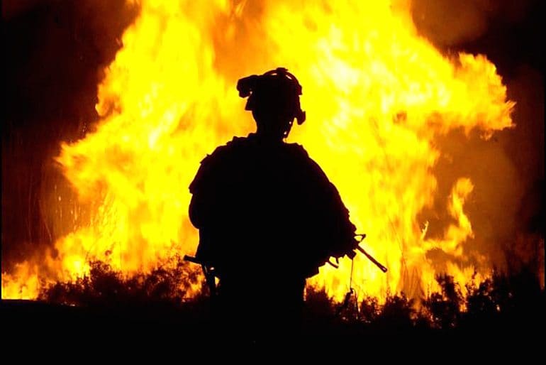 U.S. Army Sgt. William Reese watches flames rise into the night sky after setting canal vegetation ablaze in Tahwilla, Iraq, July 30, 2008. Extremists have been using the canal's thick vegetation to plant bombs under the cover of darkness. The soldiers are assigned to Company B, 1st Battalion, 6th Infantry Regiment.U.S. Army photo by Spc. David J. Marshall