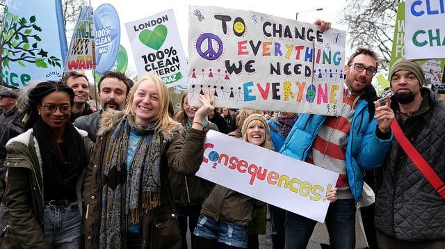 Activists waving placards and banners at the climate change march in London on 29 November 