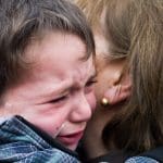 A child crying in his mother's arms child poverty People's Assembly