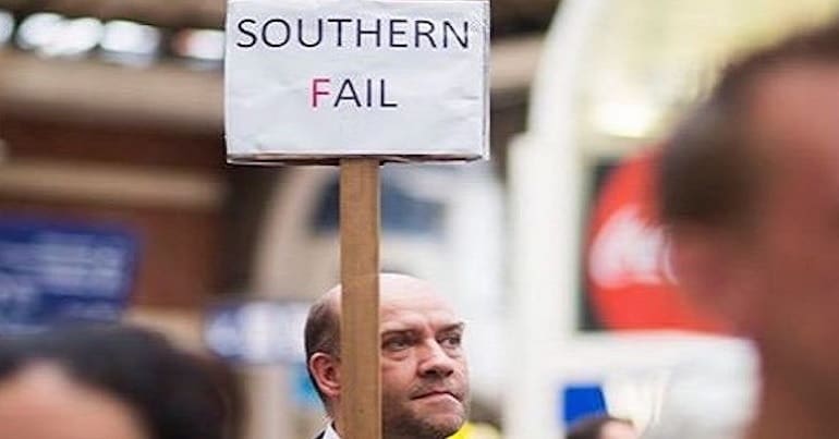 A man holding a protest sign about Southern Rail