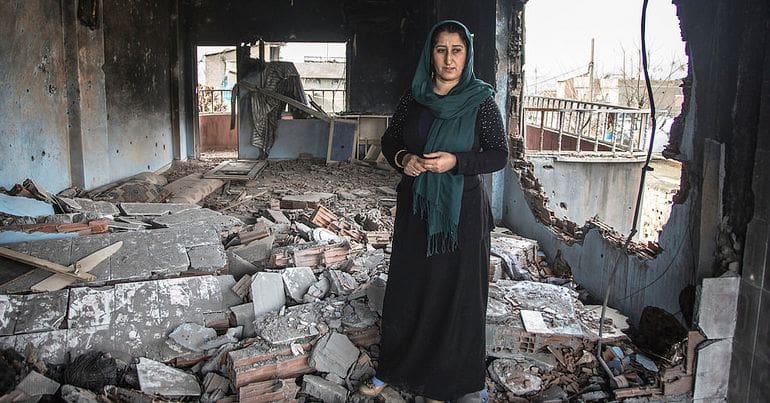 Kurdish Woman standing in bomb wreckage, Cizre