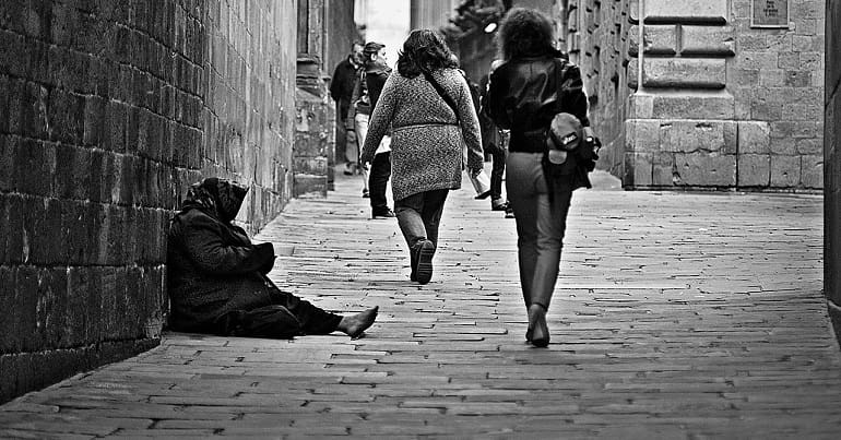 Homeless old woman on street showing poverty