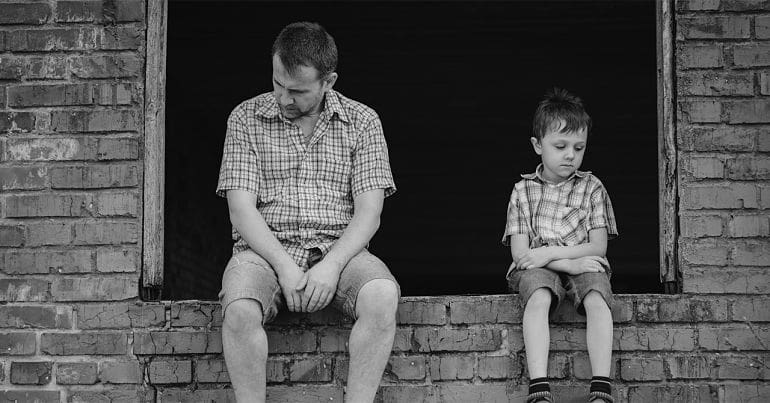 Man and boy sitting on wall homelessness