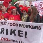 McDonalds workers striking - people marching and holding a strike banner