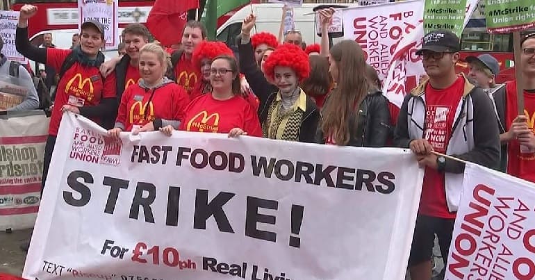 McDonalds workers striking - people marching and holding a strike banner
