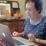 An elderly woman using a computer