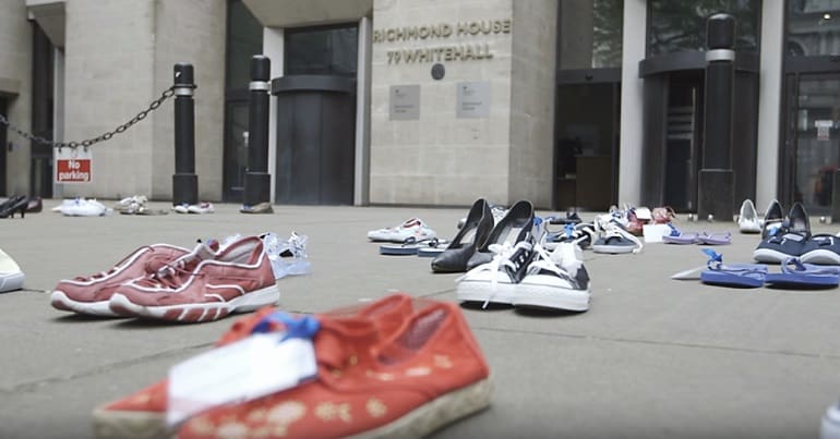 pairs of shoes arranged on the pavement - A Millions Missing protest outside the UK department of health