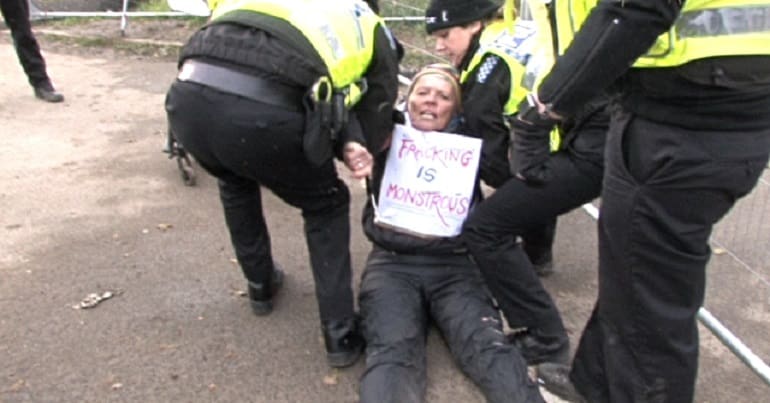 A fracking protestor being dragged away by police
