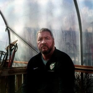 Man sitting in a greenhouse