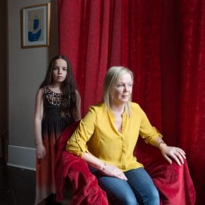 Woman in chair with child behind