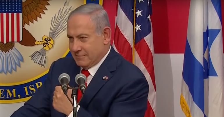 Benjamin Netanyahu at the US embassy in Jerusalem in front of American and Israeli flags
