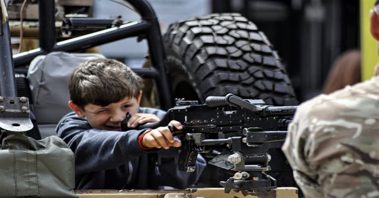 Child handels machine gun at Armed Forces Day 23 June 2018