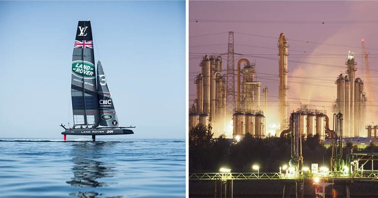 Ben Ainslie America's Cup yacht under former sponsor Land Rover and Ineos petrochemical plant in Belgium