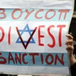 Protester holds up BDS poster