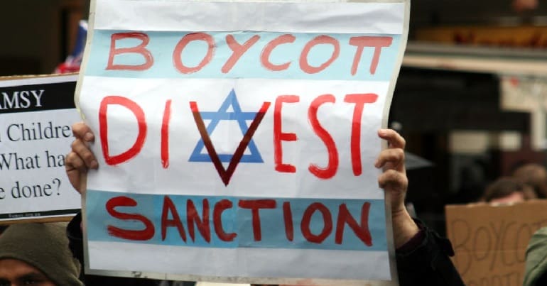 Protester holds up BDS poster