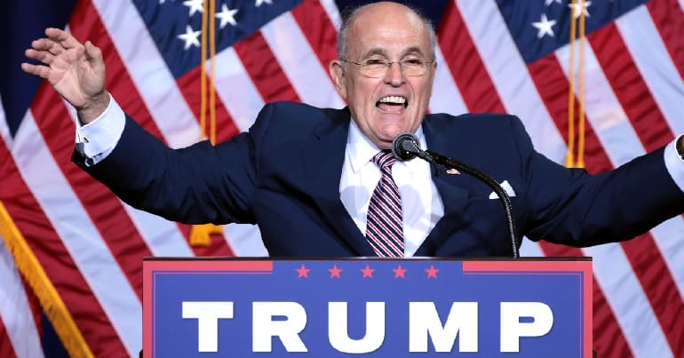 Giuliani in front of American flags