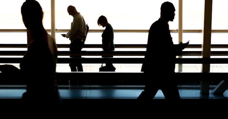 People walking along on the shadows with heads down