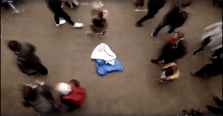 A sleeping bag being ignored in the street