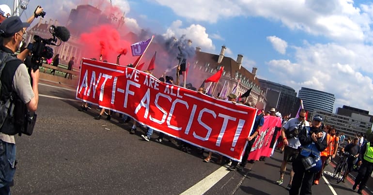 Anti-fascist protesters march with a banner across Westminster Bridge