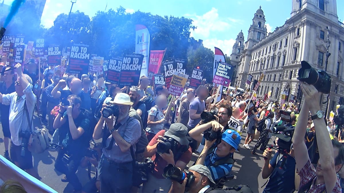 Protesters from a second march cross in front of the anti-fascist march