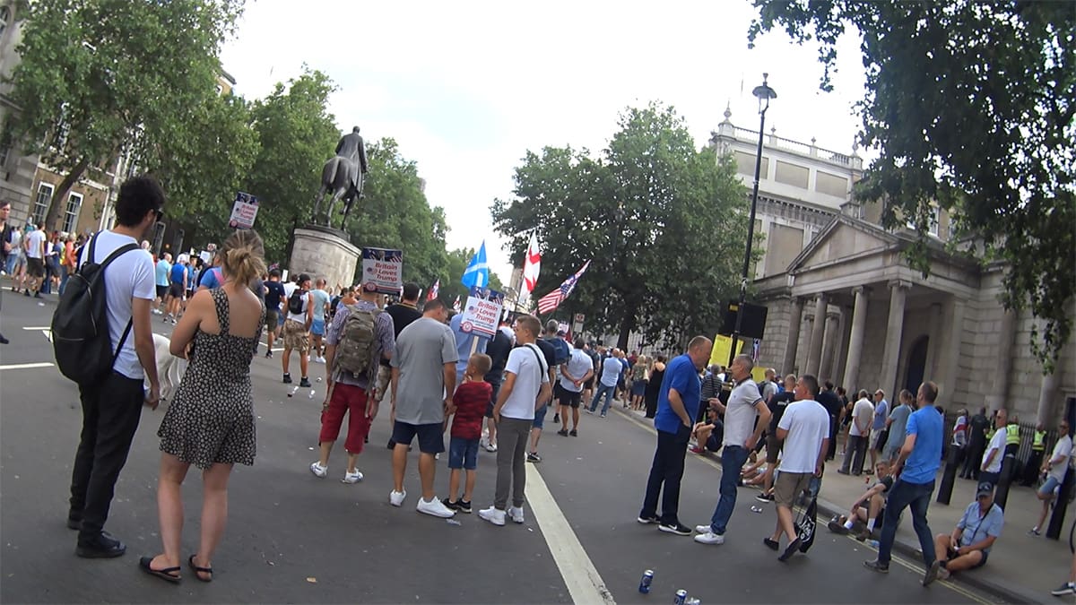 A crowd of Tommy Robinson surppoters including the flags of England, Scotland and the USA.