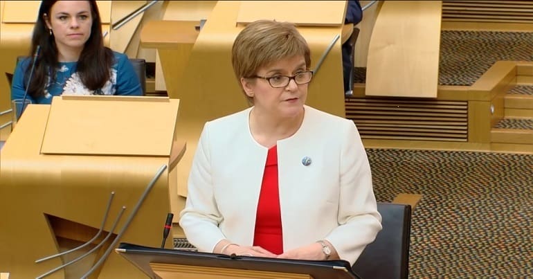 Nicola Sturgeon standing up in the Scottish Parliament