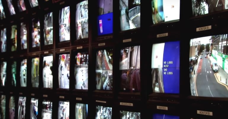 Image of multiple CCTV screens police facial recognition cameras in relation to the coronation