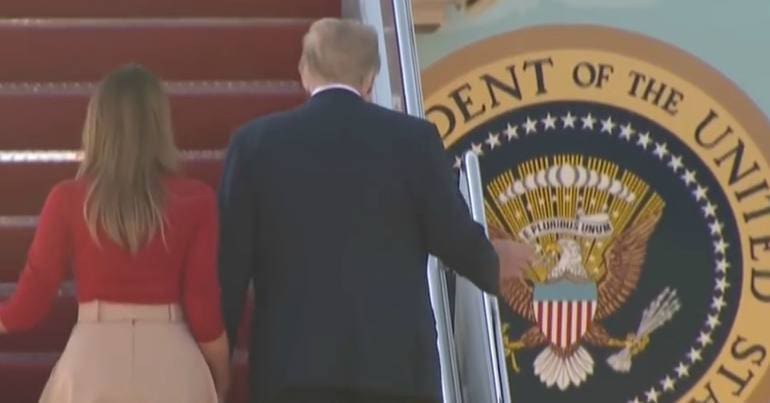 Donald Trump and Malania Trump walking up the stairs to Air Force One