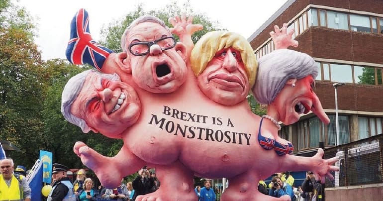 An image of a a float with Theresa May, Dave Davis, Boris Johnson, and Michael Gove fused as a big monster. It says 'BREXIT IS A MONSTROSITY' on it. Brexit