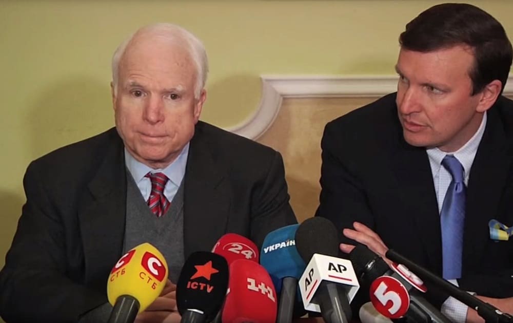 Republican McCain sits with Democrat Chris Murphy at a press conference in Kiev, Ukraine