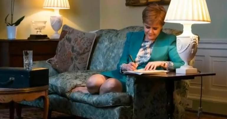 Nicola Sturgeon signing a letter to Theresa May