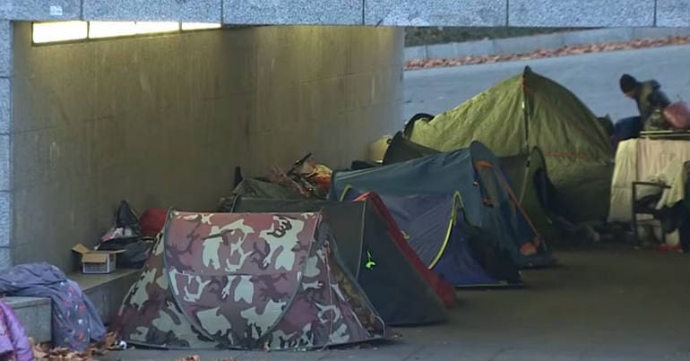 Homeless people's tents under a bridge