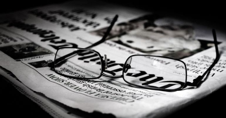Image of glasses on top of a newspaper