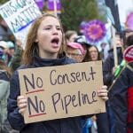 Protesters hold placards against the Trans Mountain expansion project