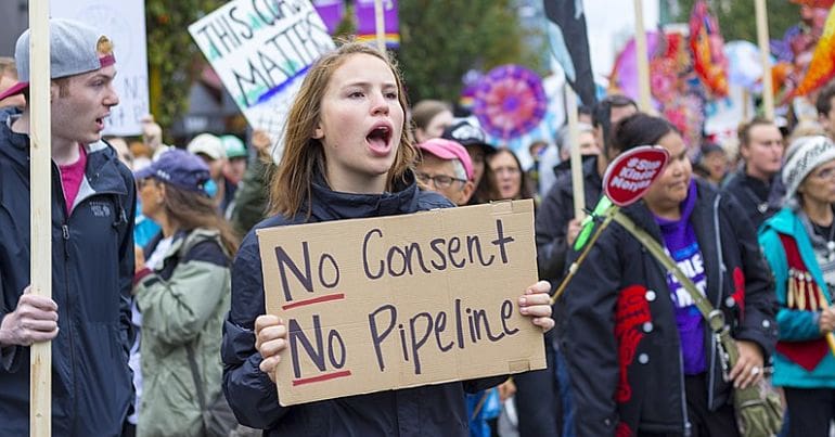 Protesters hold placards against the Trans Mountain expansion project