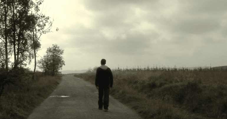 Man walking down empty road