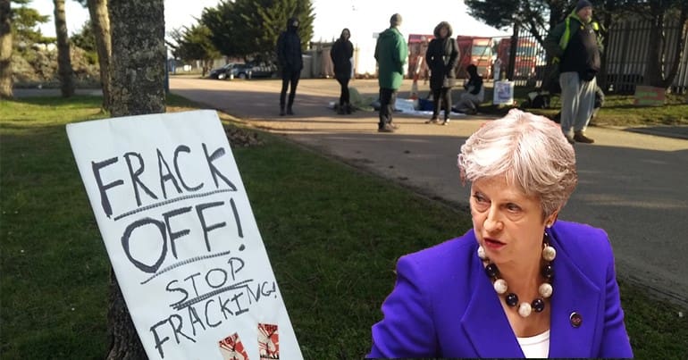 A fracking protest sign and Theresa May