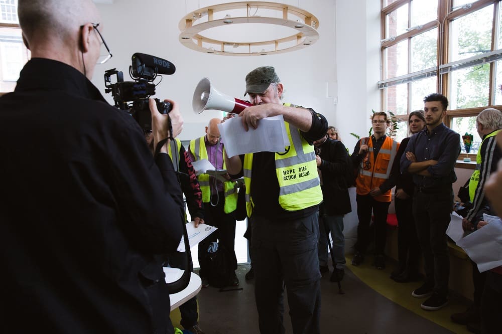 An activist with a megaphone at the Greenpeace office