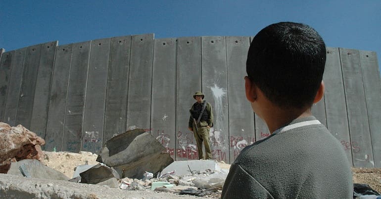 Israel-Palestine wall with soldier and child in front