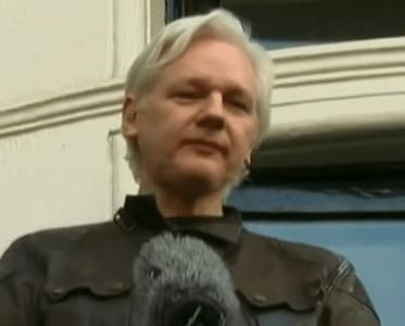 Julian Assange standing on balcony of the Ecuadorian embassy in London
