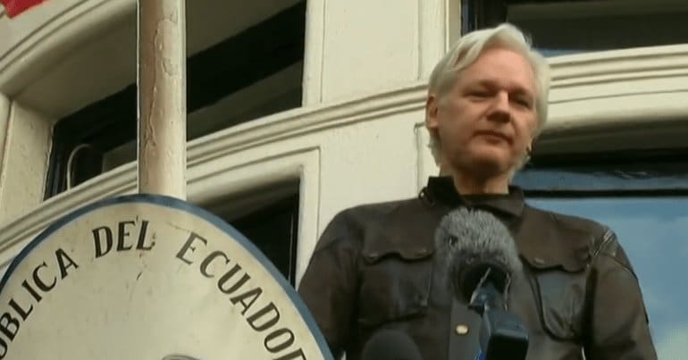 Julian Assange standing on balcony of the Ecuadorian embassy in London