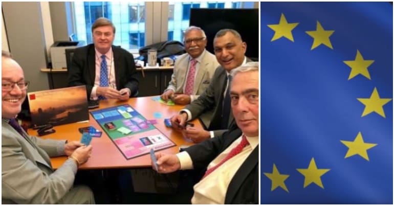 Tory MEP's playing a Brexit themed board game next to an EU flag