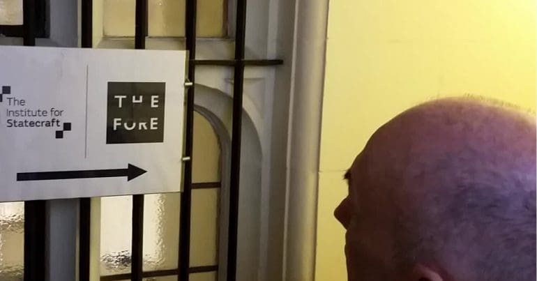 Chris Williams MP outside of IfS office in front of sign on 19 December 20187