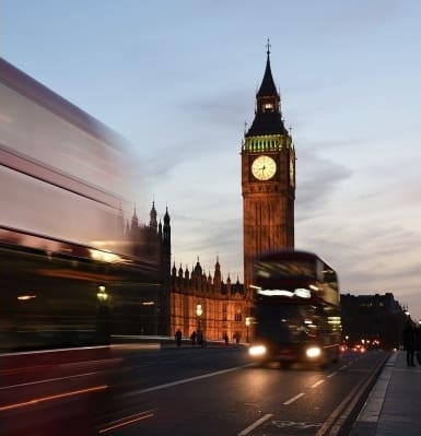 Theresa May and a London bus next to houses of parliament