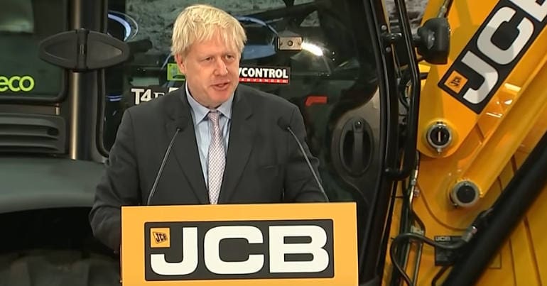 Boris Johnson giving a speech in front of a JCB digger