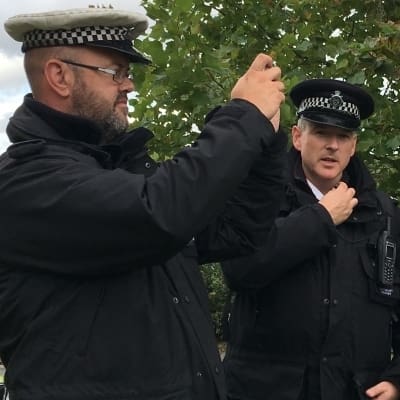 Police with cameras and the DWP logo