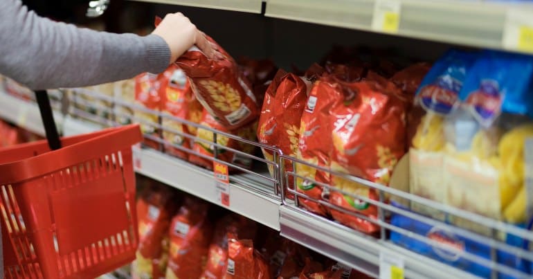 Woman buying pasta at a supermarket.