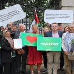 A small number of protesters outside of the Irish parliament holding up pro-Palestine banners