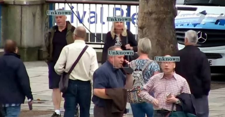 People in a crowd being scanned by facial recognition cameras