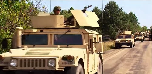 Military vehicles mounted with machine gunners
